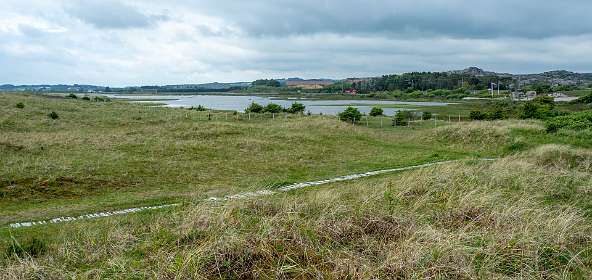 We lopen achter het duin terug